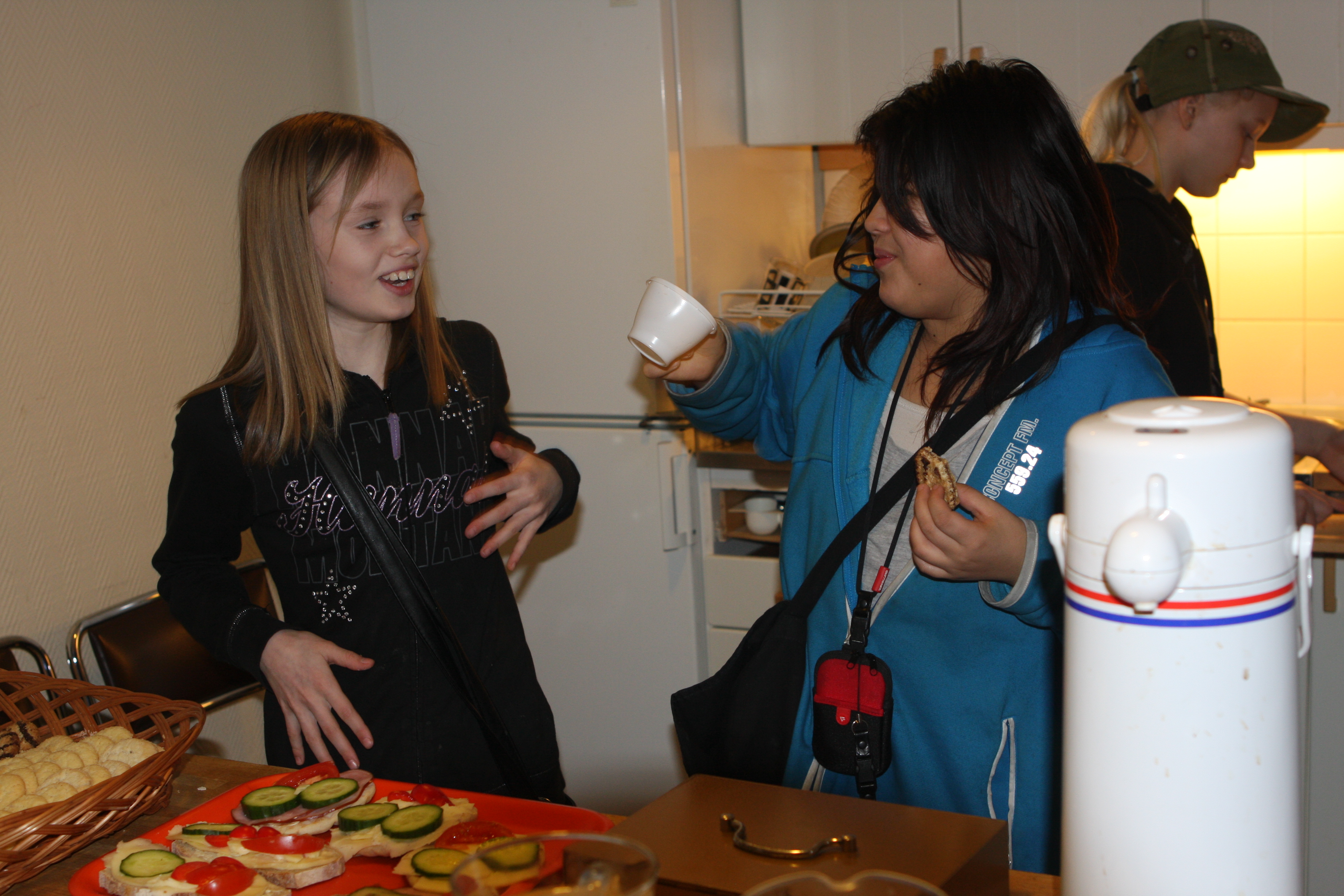 Therese Nätstrand och Johanna Nabbing hjälper till (?) i serveringen. I bakgrunden Annie Kildén.